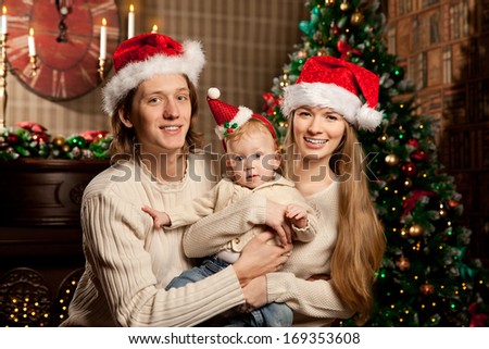 Happy smiling family near the Christmas tree celebrate New Year