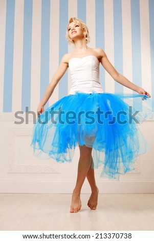 Dancer, ballerina. Cute woman looks like a doll in a sweet interior. Young pretty smiling girl