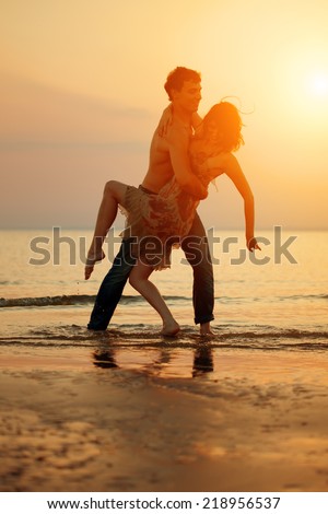 Summer fun holiday on beach background. Couple in love in beach party. Summer scene about dance,  dancing, sunset sky
