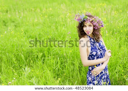 The image of a girl wearing a wreath of wild flowers in the field