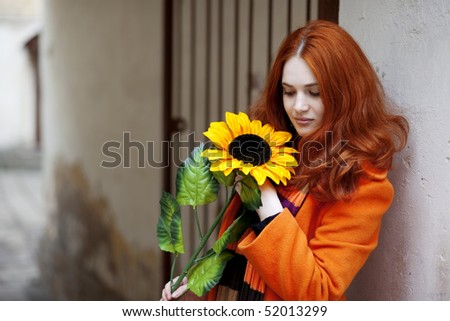The image of a pretty girl walking with a sunflower city