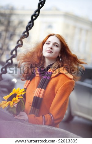 The image of a pretty girl walking with a sunflower city