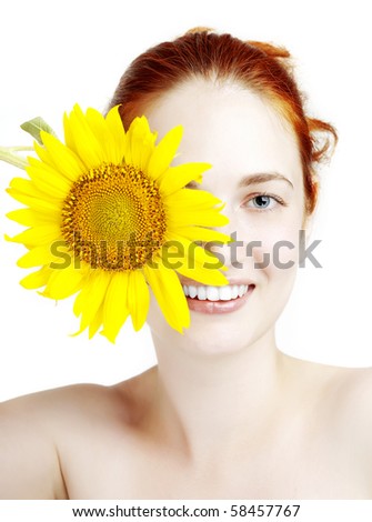The image of a beautiful smiling girl with a sunflower in the hands