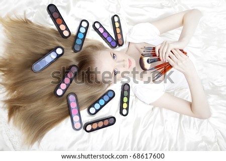 Image of girl stylist makeup artist with brushes and cosmetics