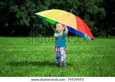 The image of a little boy with a big rainbow umbrella