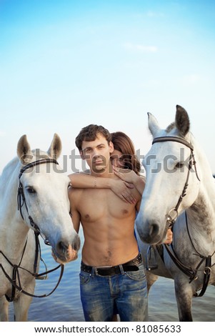 Image of a man and a woman in love with the sea with horses