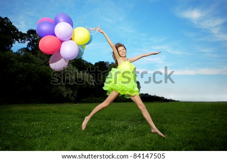 Bright happy woman holding bunch of colorful air balloons