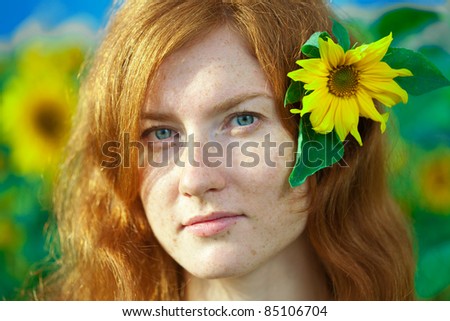 Beautiful red-haired woman with sunflowers