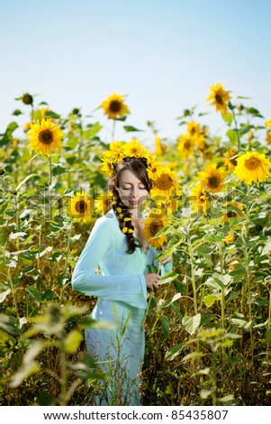 Woman with big blue eyes in a field of sunflowers