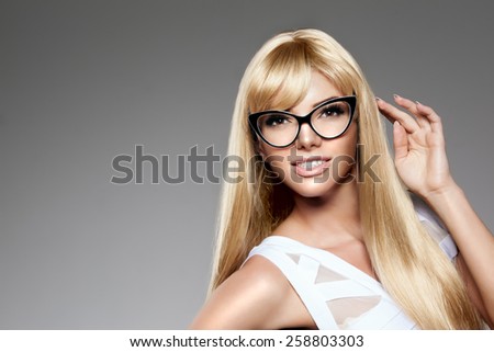Beauty young woman luxury long blond hair in glasses Haircut, fringe Girls fresh healthy skin, makeup lips, eyelashes, manicured nails shiny. Fashion model in spa care salon Sexy trendy hairstyle look