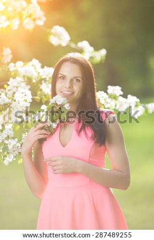 Young spring fashion woman in spring garden. Springtime. Trendy girl at sunset in spring landscape background. Allergic to pollen of flowers. Spring allergy