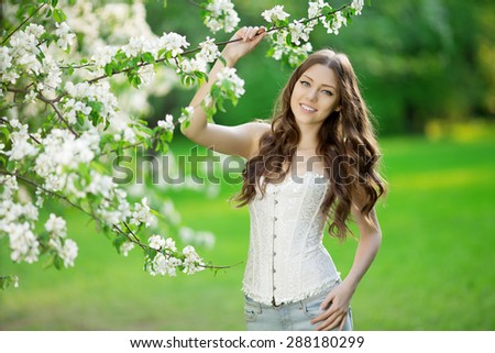 Young spring fashion woman in spring garden Springtime Summertime Trendy girl in the flowering trees in then at sunset in spring  summer landscape background Allergic to pollen of flowers Allergy