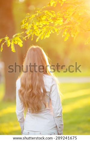 Young woman with long hair turned back  outdoors in sun light Warm Color Tones Beauty Sunshine woman Backlit Sunny Summer Day Autumn Summertime Glow Sun
