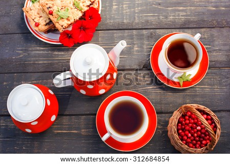 Tea cups top view. Tea time for party. Tea set red polka-dot, cookies on a wooden background.