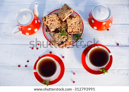 Tea cups top view. Tea time for party. Tea set red polka-dot, cookies on a wooden background.