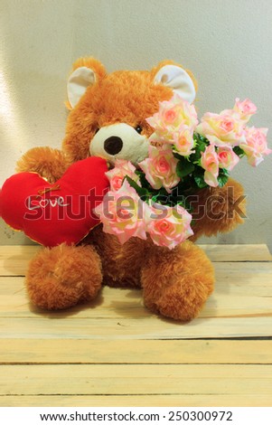 Teddy bear and heart on a wooden table.