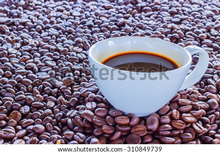 Coffee wallpaper, background, grains of coffee plant and black coffee drink in white coffee set. Coffee time texture.