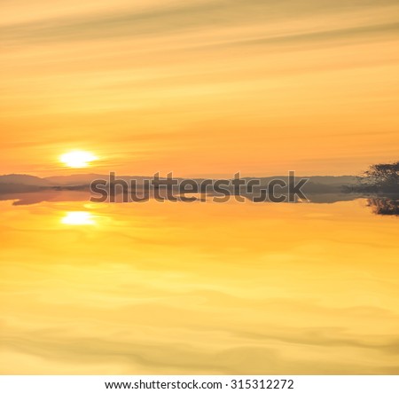 clouded orange sky and mountain silhouette with shadows on the water
