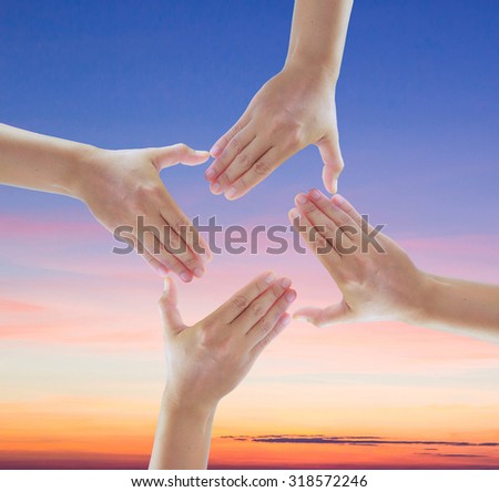 Four aiming hand signs created a frame with sky gradient from blue to orange sunset