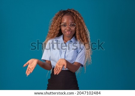 black woman with curly hair in studio photo wearing blue shirt and black skirt and making various facial expressions. Foto d'archivio © 