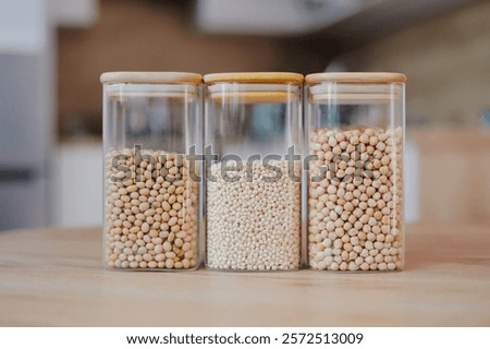 Similar – Image, Stock Photo Three glass jar container full with dried raw pasta in an empty room