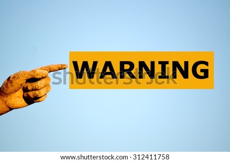 finger with rectangular orange label WARNING