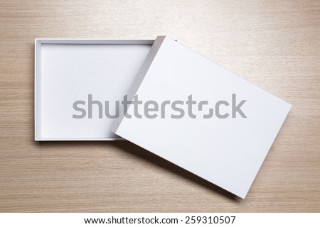Open empty white box on wooden table