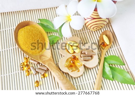 Herbal supplements and vitamins  on wooden tray and wooden spoon, decorated with white flowers and green leafs background as bamboo blinds white cotton cloth