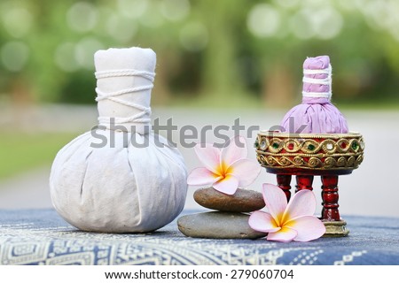 Thai traditional medicine. Body herbal ball, aromatherapy,pink yellow frangipani. Background is Blue Thai fabrics