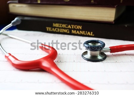 vintage picture of stethoscope and EKG graph and medical textbooks.