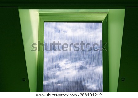 Sun through the rain. Fragments of wall, ceiling and window casement with a view of rainy sky in a concept of green technologies, environmental conservation or window of opportunity.