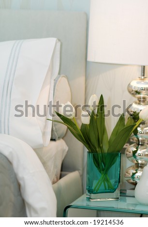 Vase with white tulips on the drawers in the bedroom
