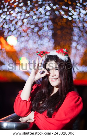 Santa woman dressing. Standing under the lights during the Christmas decorations. Smiling and happy during Christmas.