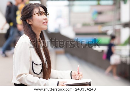Smile and relax businesswoman.businesswoman writing paper and hold document file.sitting on sidewalk.