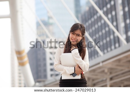 Happy asian businesswoman hold paper and document file.smile and stand on sidewalk.