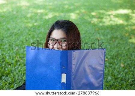 Female student remove the face cover. Sitting on lawn