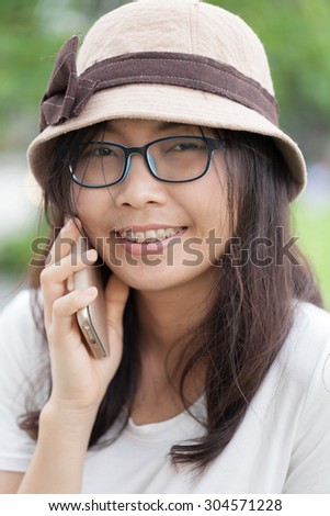 asia woman talk phone and smile.woman wear hat and eyeglasses.