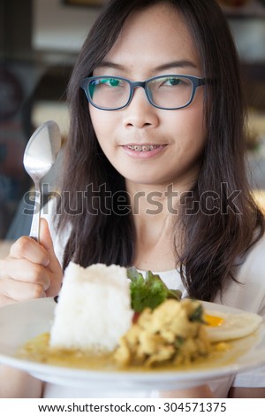 asia woman hold thai food.woman wear eyeglasses. relax and smile wear eyeglasses and hold spoon.