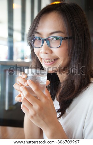 Asia woman drink water.smile woman dring water.woman wear eyeglasses smile and relax.