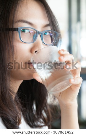 Asia woman drink water.smile woman dring water.woman wear eyeglasses smile and relax.