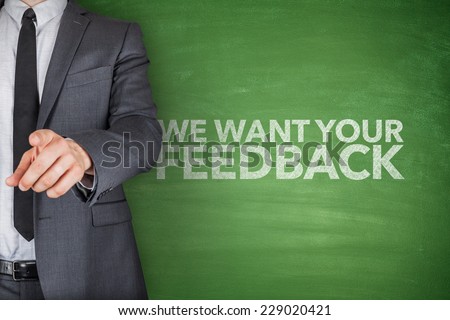 We want your feedback on blackboard with businessman hand pointing