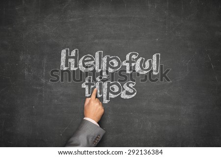 Helpful tips concept on black blackboard with businessman hand