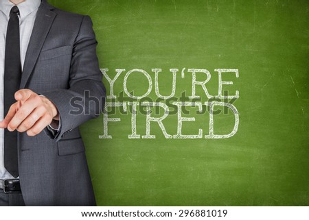 Youre fired on blackboard with businessman finger pointing
