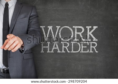 Work harder on blackboard with businessman finger pointing
