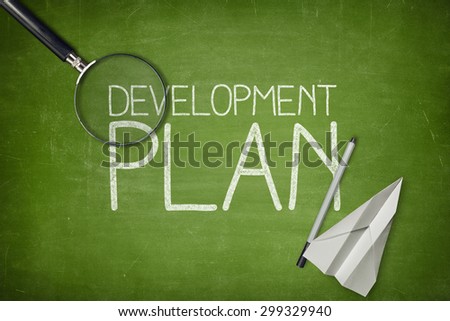 Development plan concept on green blackboard with empty paper sheet and coffee cup