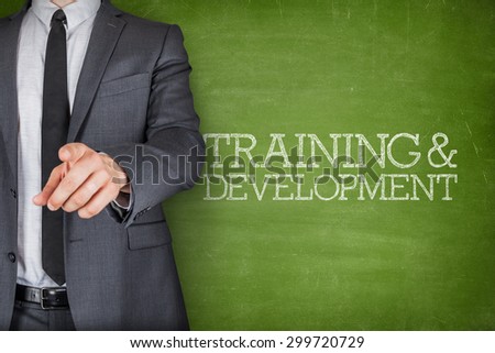 Training and development on blackboard with businessman finger pointing