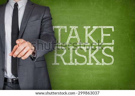 Take risks on blackboard with businessman finger pointing