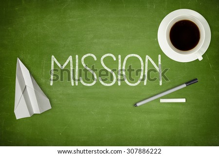 Mission concept on green blackboard with coffee cupt and paper plane