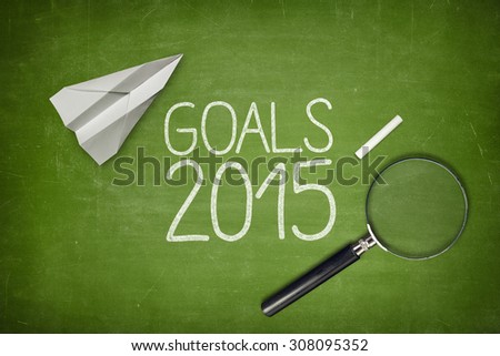Goals 2015 concept on green blackboard with empty paper sheet and coffee cup