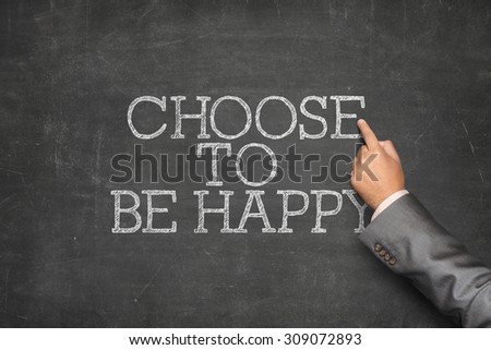 Choose to be happy text on blackboard with businessman hand pointing